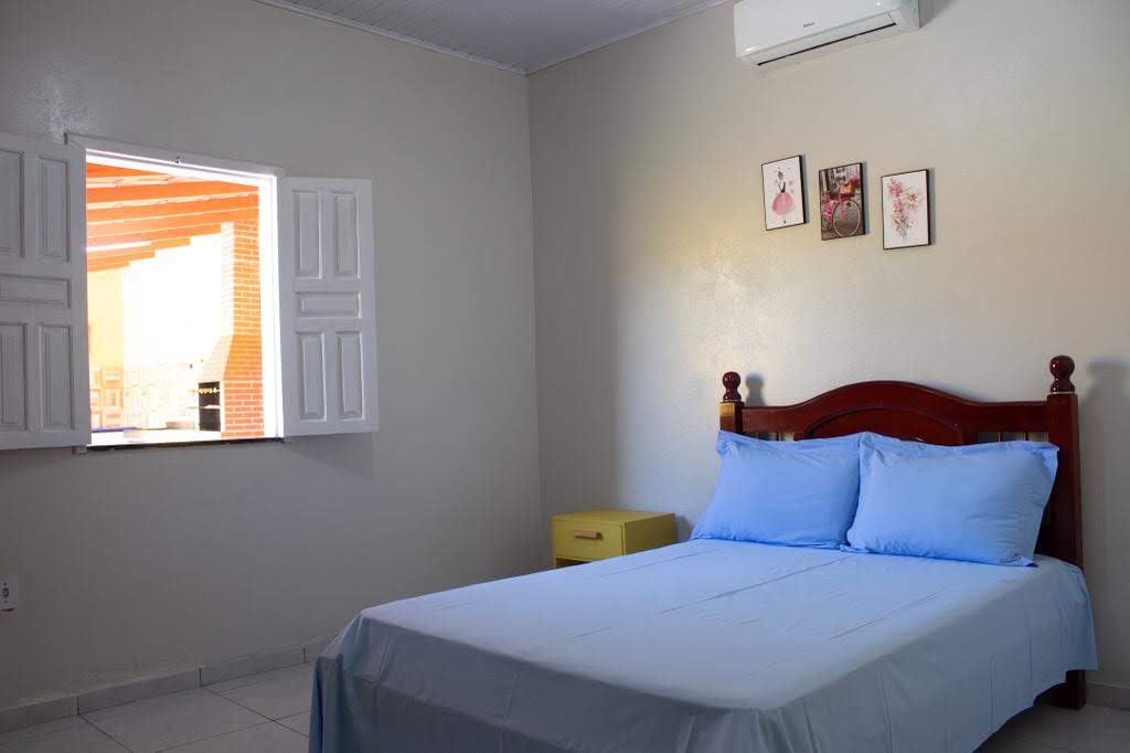 Suíte confortável da Casa Amarela com cama de casal e ar-condicionado em Alcobaça-BA