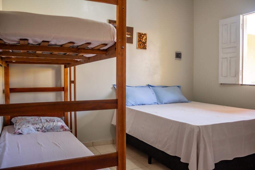 Quarto da Casa Amarela com cama de casal, beliche e ar-condicionado em Alcobaça-BA