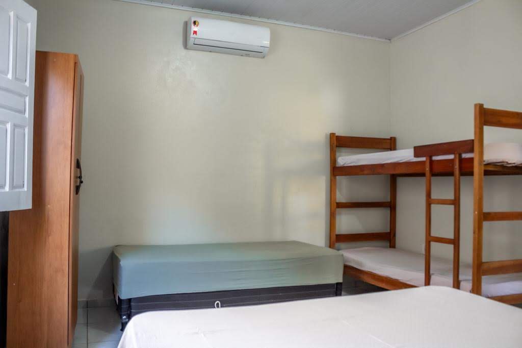 Ambiente aconchegante com cama de casal, beliche e ar-condicionado na Casa Amarela em Alcobaça-BA