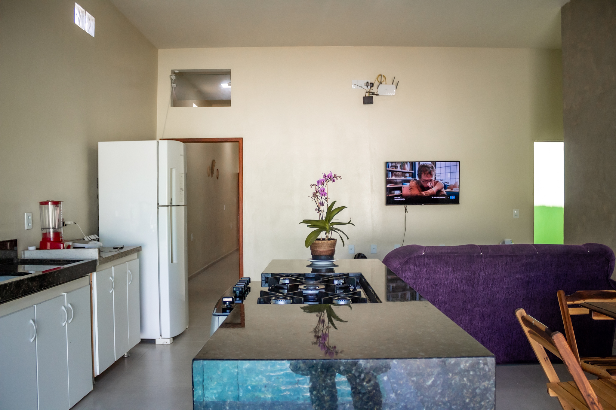 Ambiente moderno com sala e cozinha integradas na Casa Verde em Alcobaça-BA